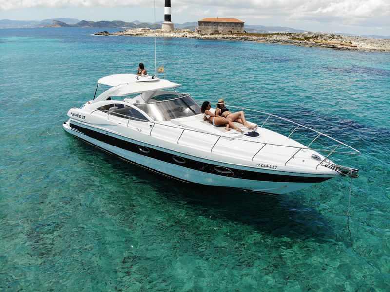 Pershing 37 yacht sailing in Ibiza’s turquoise waters, available for hire with experienced skipper included